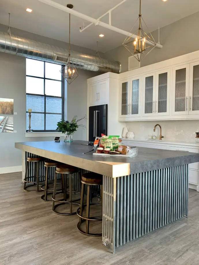 gray metal island table near white wooden kitchen cabinet